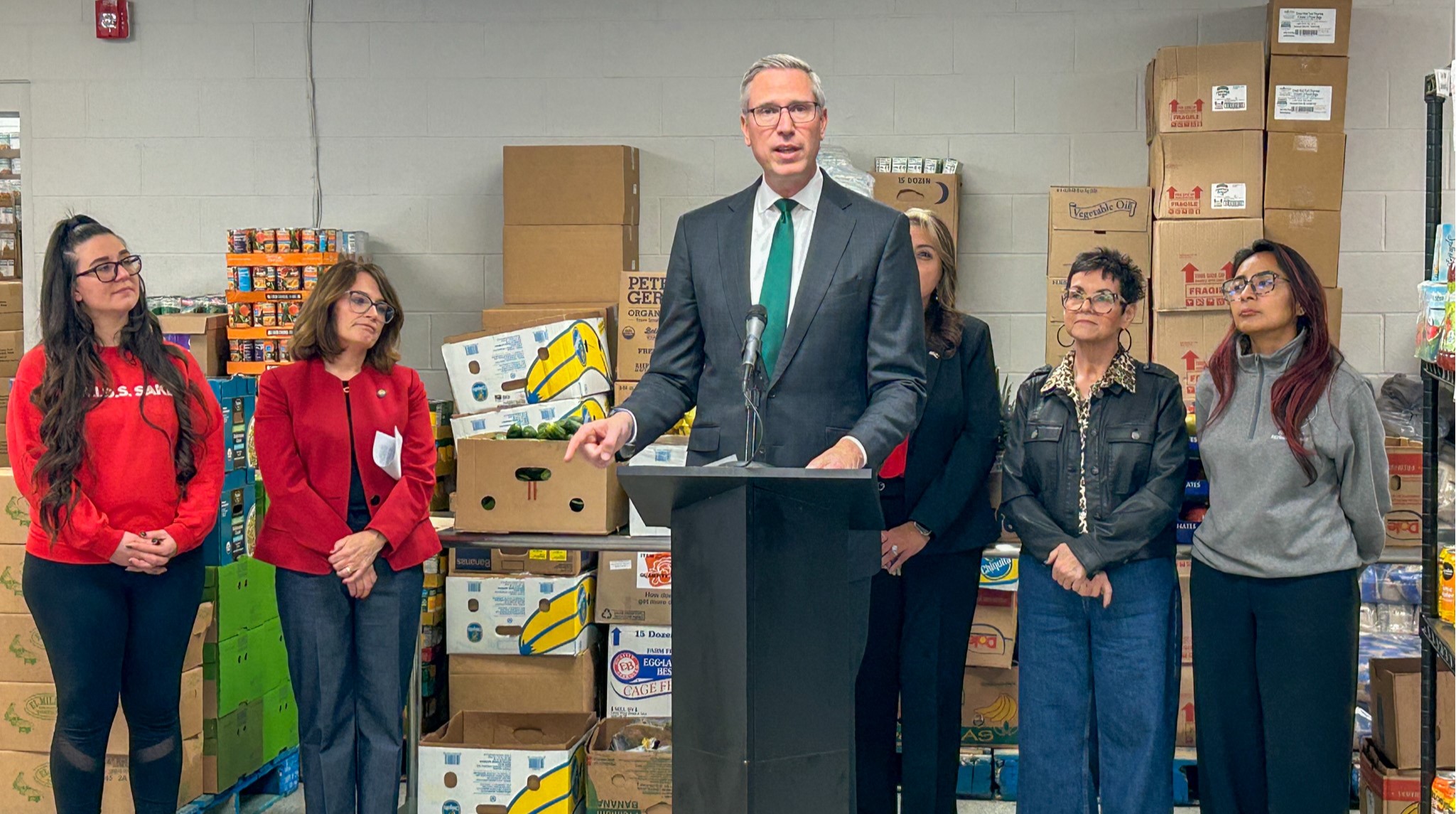 Treasurer Frerichs speaks as others stand near him at a food pantry