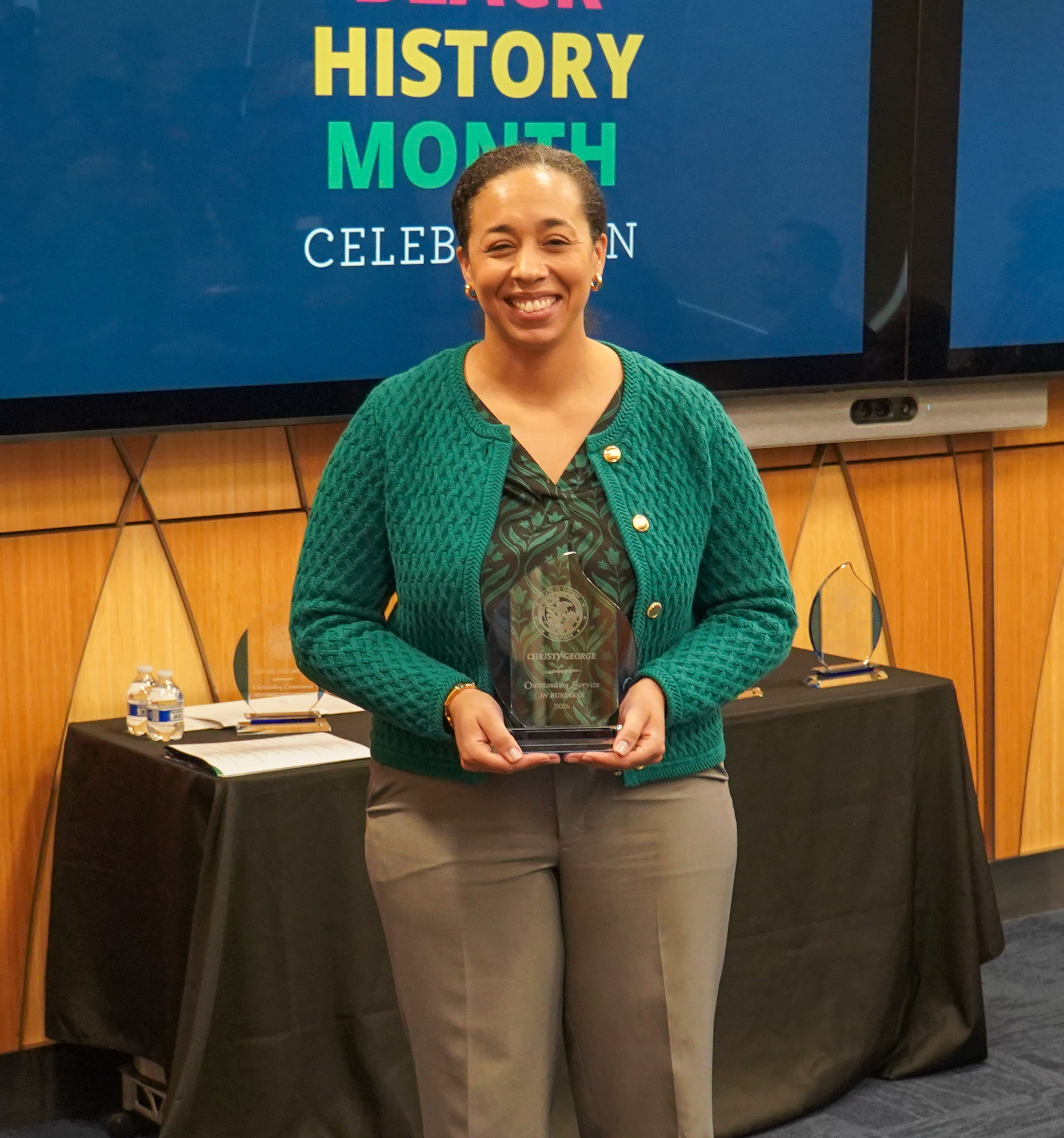 Christy George holding her Outstanding Service in Business award