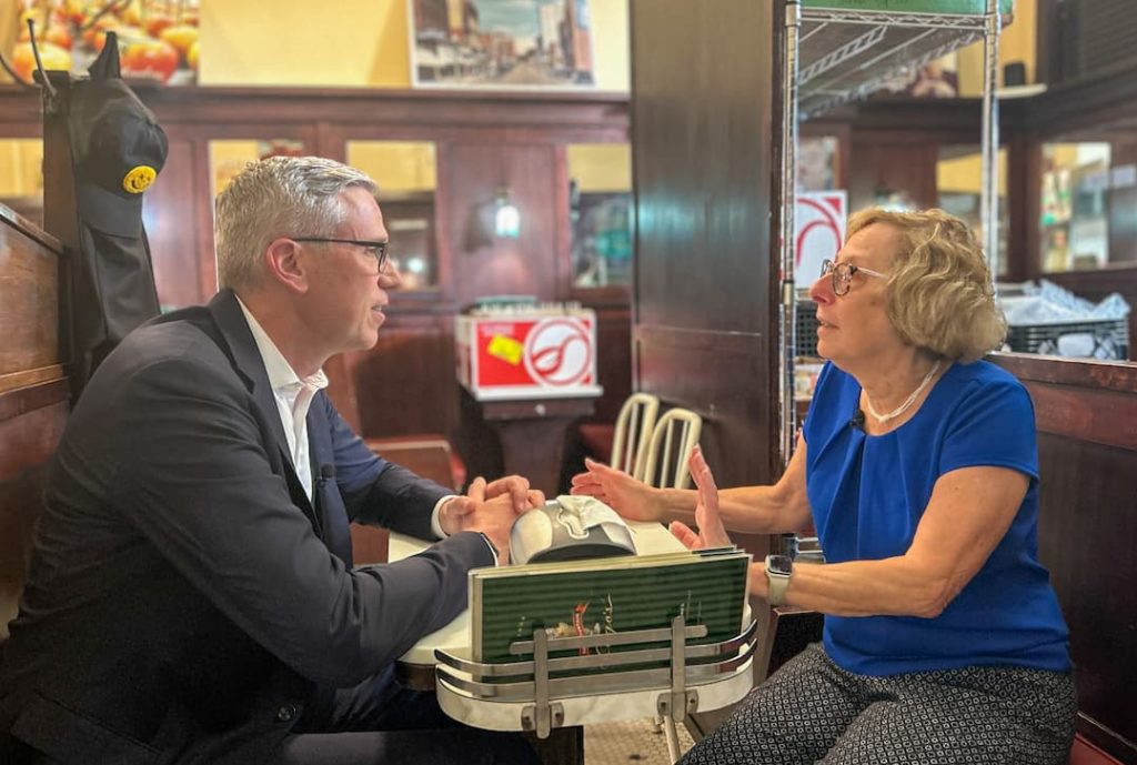 a man and women sit in a diner having a conversation