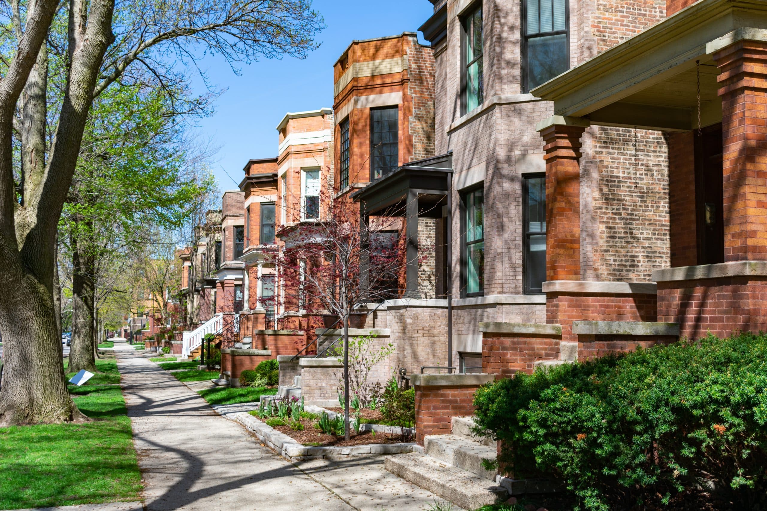 city street in spring with rows of houses and front stoops in Chicago area. 